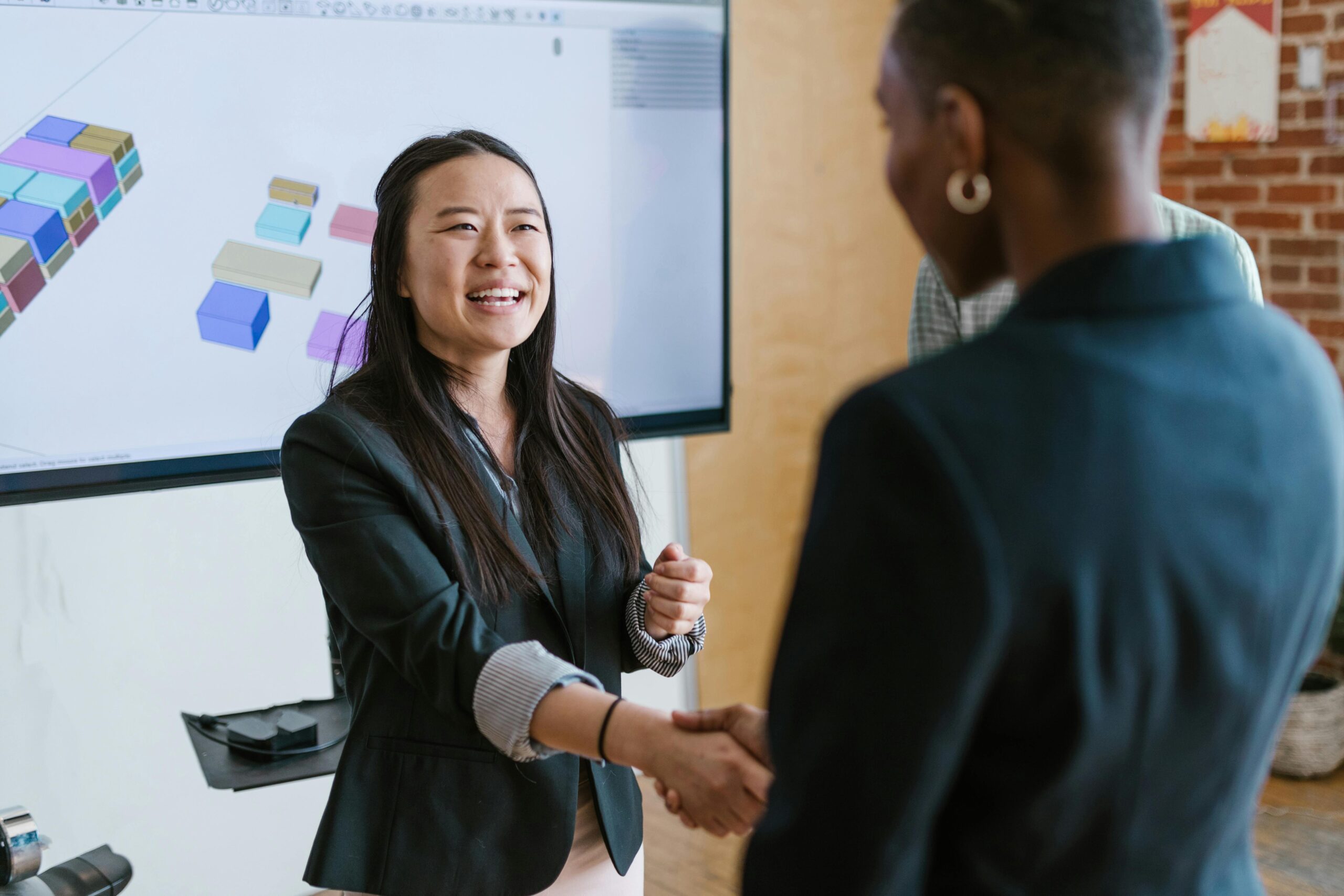 two women shaking hands in an office