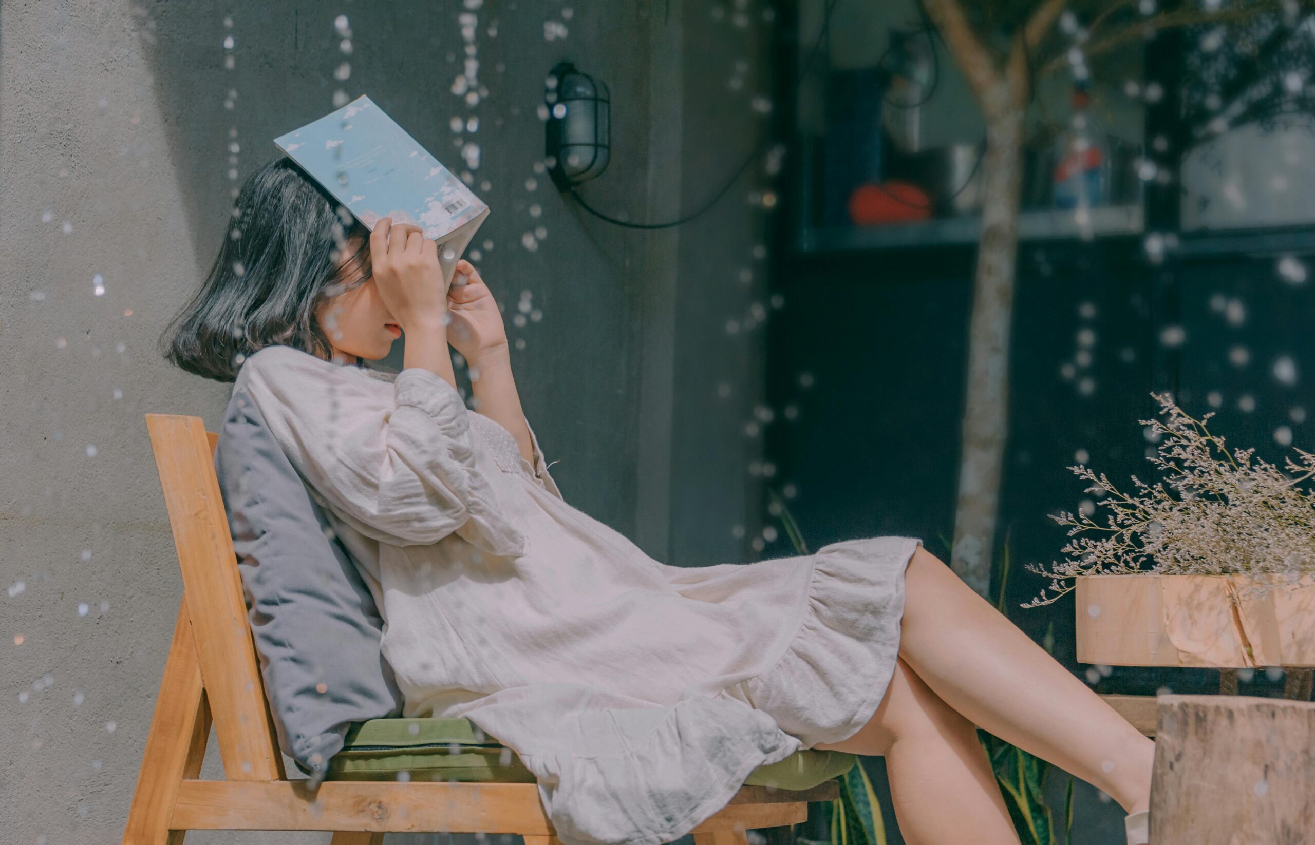 woman blocking raindrops with a book